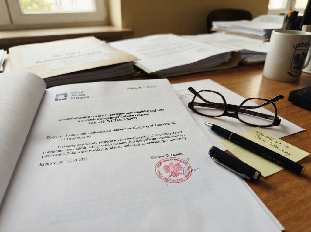 Dokument urzędowy dotyczący nielegalnej reklamy leżący na biurku